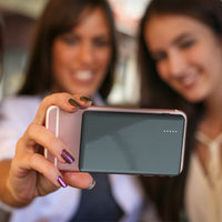 Two women taking a selfie with a smartphone, blurred background